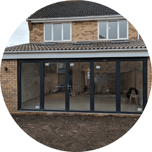 An image of a house extention with black framed bifolding doors